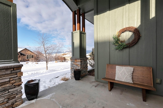 snow covered patio with a porch