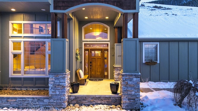 snow covered property entrance featuring a porch