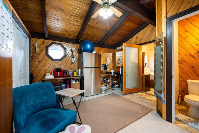 living area with wooden walls, light colored carpet, lofted ceiling with beams, ceiling fan, and wooden ceiling