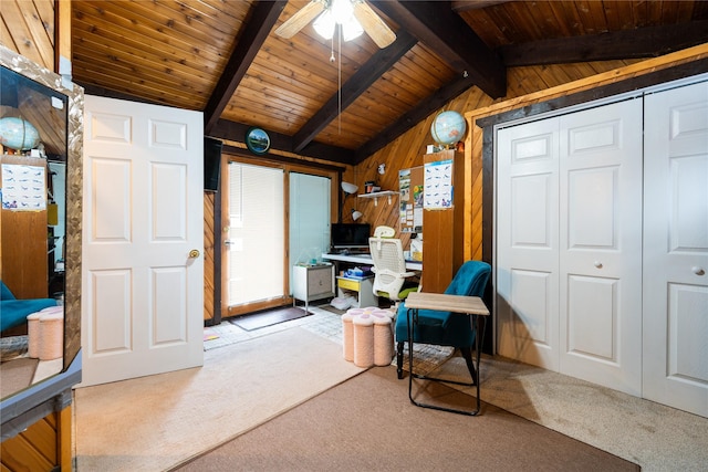 interior space featuring lofted ceiling with beams, wooden ceiling, wooden walls, carpet floors, and a wealth of natural light