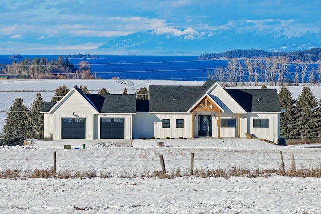 view of front of property featuring a garage and a water and mountain view