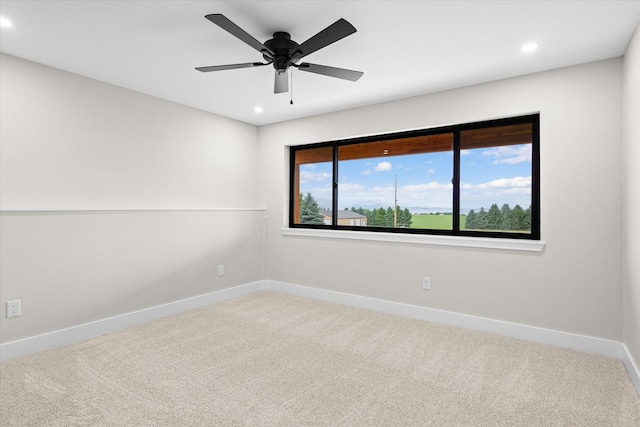 carpeted spare room with ceiling fan