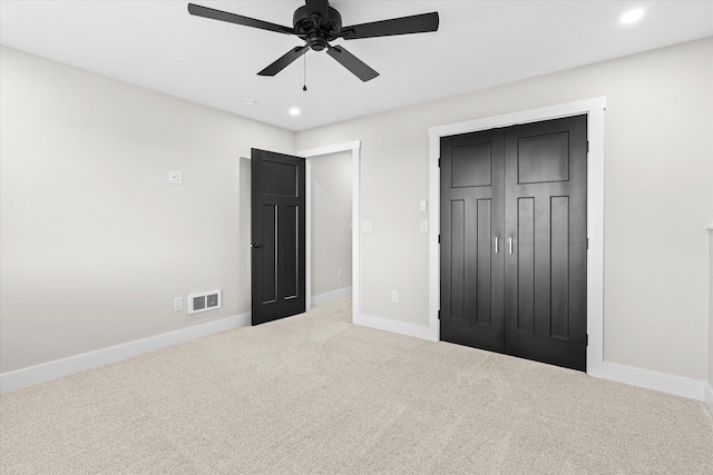 unfurnished bedroom with a closet, ceiling fan, and carpet flooring