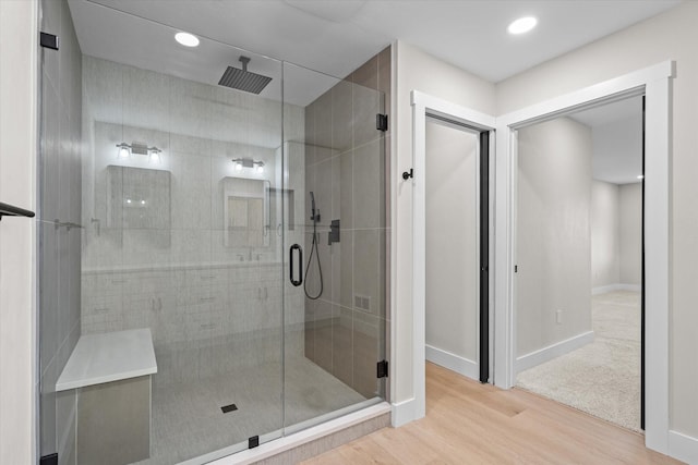 bathroom with walk in shower and wood-type flooring