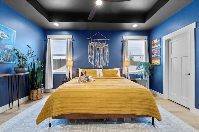 bedroom featuring hardwood / wood-style flooring and a raised ceiling