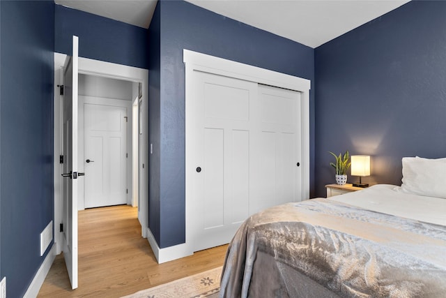 bedroom with a closet and light hardwood / wood-style flooring