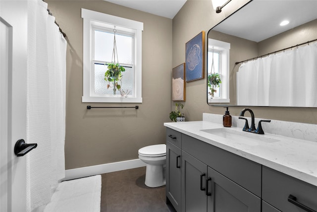 bathroom with tile patterned flooring, vanity, plenty of natural light, and toilet