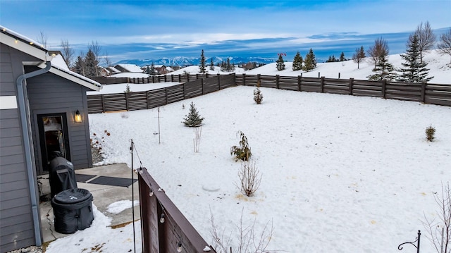 yard covered in snow featuring a mountain view