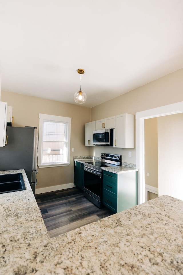 kitchen with white cabinetry, appliances with stainless steel finishes, sink, and hanging light fixtures