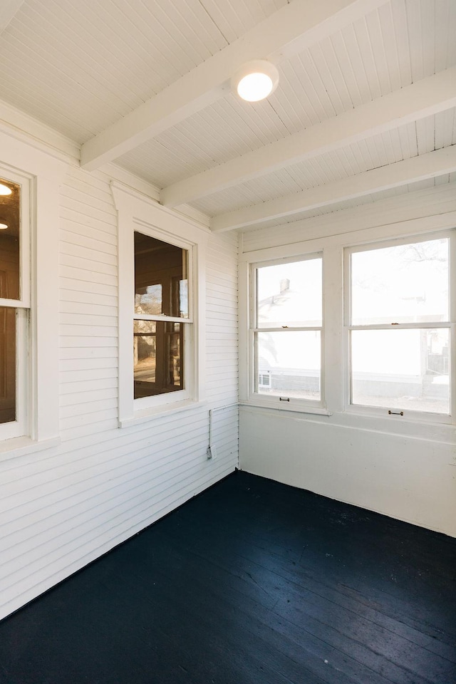 unfurnished sunroom featuring beam ceiling