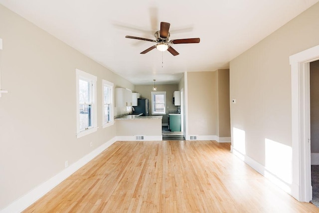 unfurnished living room with ceiling fan and light wood-type flooring