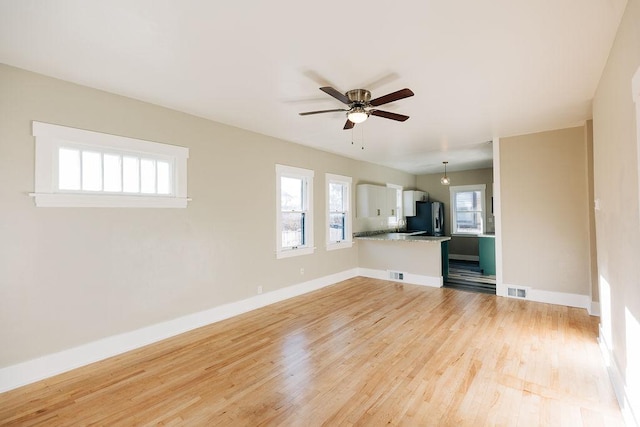 unfurnished living room with ceiling fan and light wood-type flooring