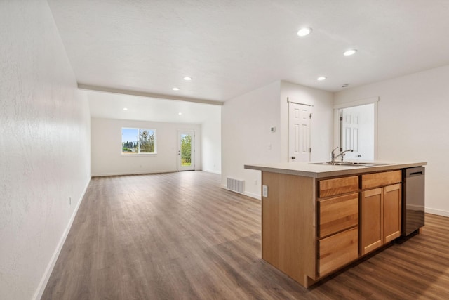 kitchen featuring dark hardwood / wood-style flooring, sink, an island with sink, and dishwasher