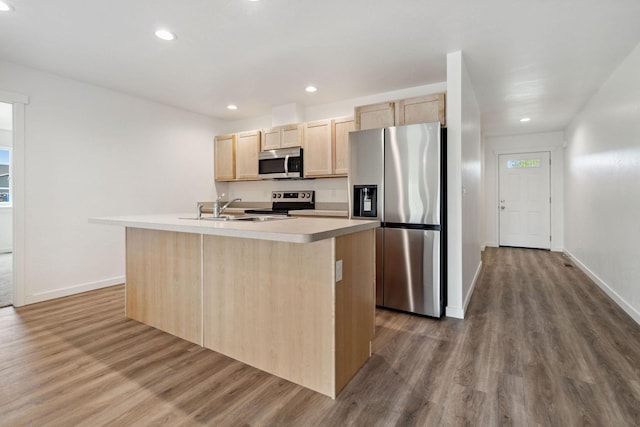 kitchen with light brown cabinets, an island with sink, and appliances with stainless steel finishes