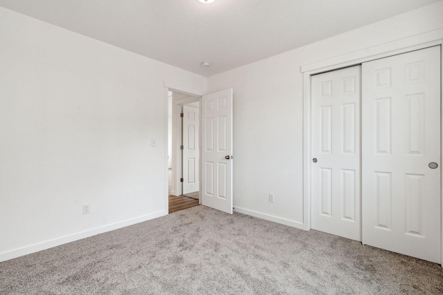 unfurnished bedroom with light carpet and a closet