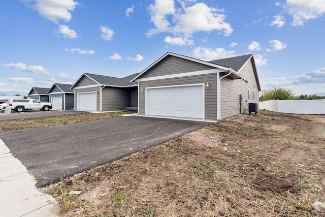 ranch-style house featuring a garage and central AC unit