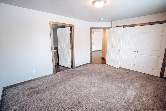 unfurnished bedroom featuring dark carpet and a closet