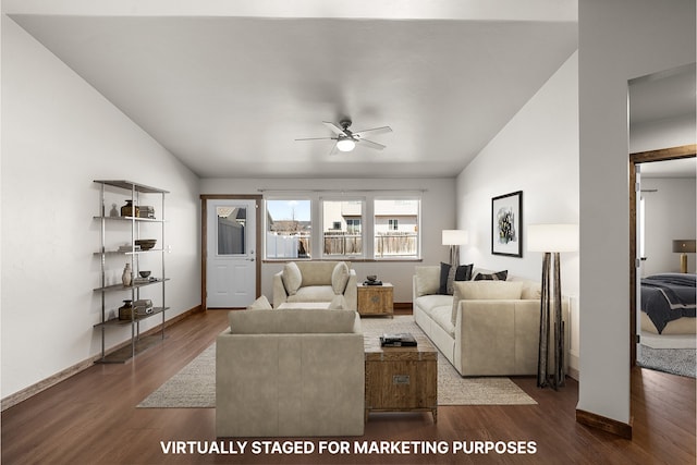 living area with a ceiling fan, vaulted ceiling, dark wood-style flooring, and baseboards