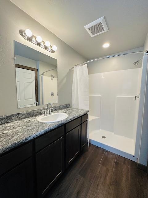 bathroom featuring vanity, hardwood / wood-style floors, and curtained shower