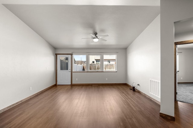 unfurnished living room featuring ceiling fan, wood finished floors, and baseboards