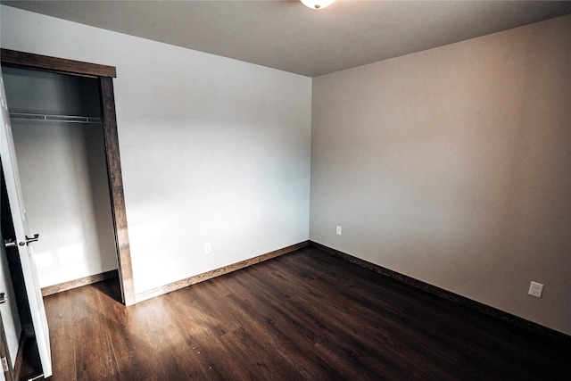 unfurnished bedroom with dark wood-type flooring and a closet