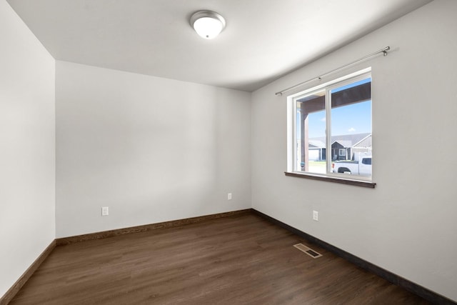 spare room with wood finished floors and baseboards