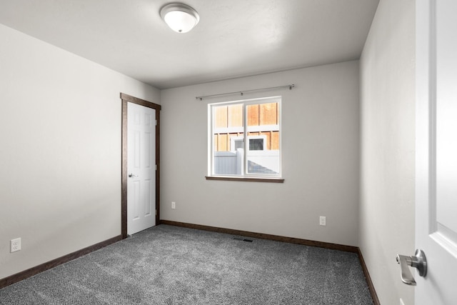 unfurnished room featuring carpet floors and baseboards