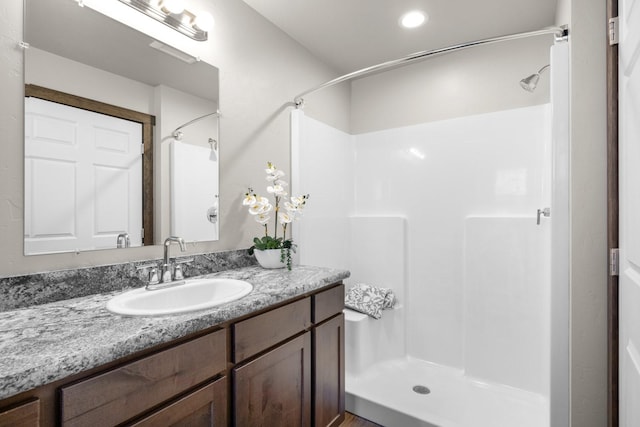 bathroom featuring a shower stall, vanity, and recessed lighting