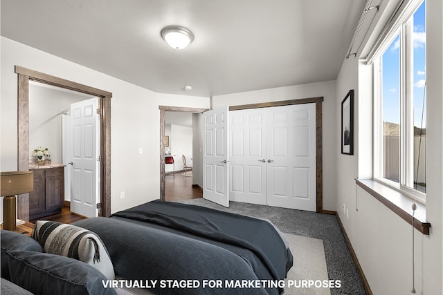 bedroom with multiple windows, a closet, baseboards, and dark carpet