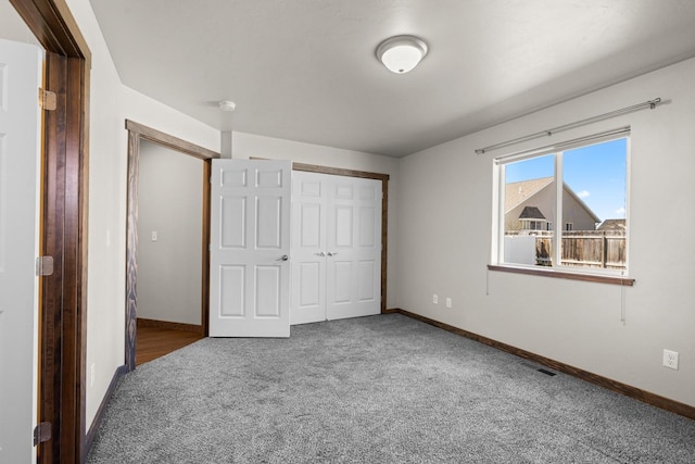 unfurnished bedroom featuring carpet, baseboards, and a closet