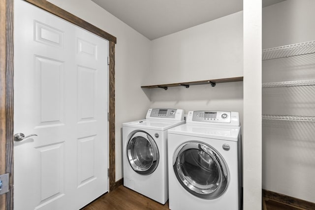 laundry room with washing machine and clothes dryer, dark wood-style floors, and baseboards
