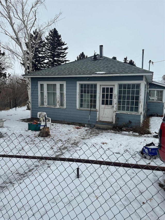 view of snow covered back of property