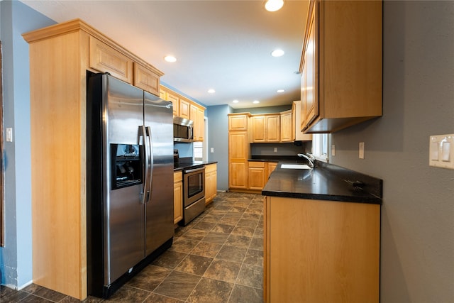 kitchen featuring stainless steel appliances, light brown cabinetry, and sink