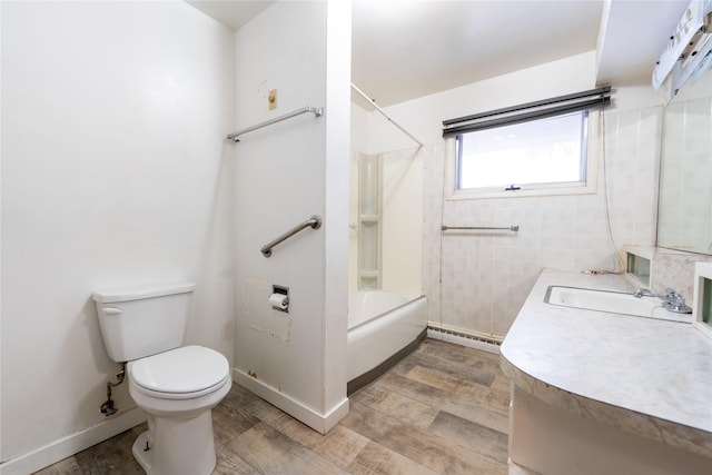 full bathroom featuring baseboard heating, tiled shower / bath, vanity, and toilet