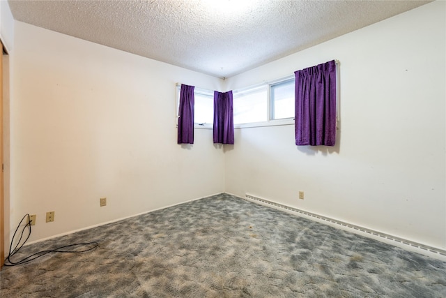 unfurnished room with carpet floors, a baseboard heating unit, and a textured ceiling