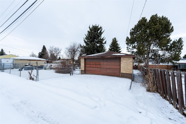 yard covered in snow with a garage and an outdoor structure