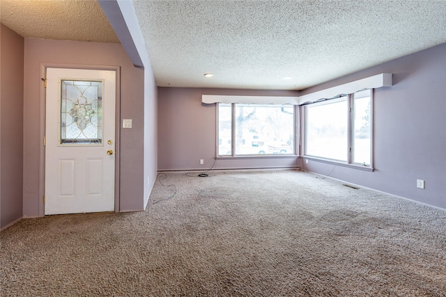 carpeted entryway with a wealth of natural light and a textured ceiling