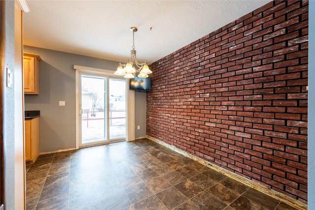 unfurnished dining area with brick wall and a notable chandelier