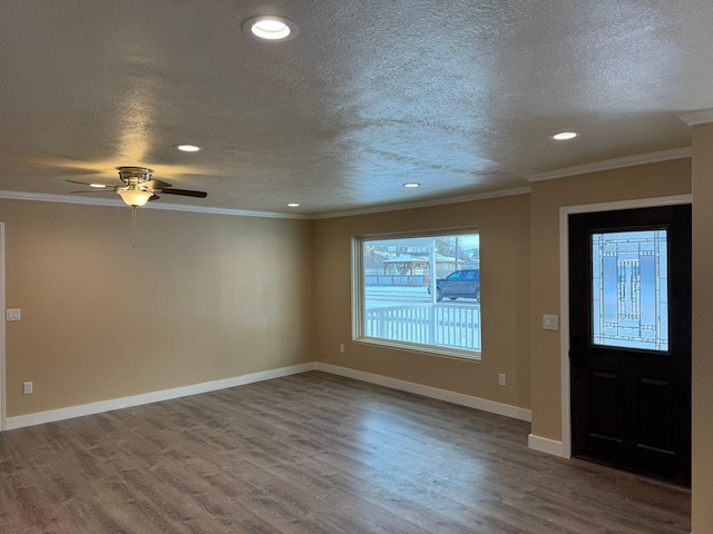 entryway featuring ceiling fan, ornamental molding, wood-type flooring, and a textured ceiling