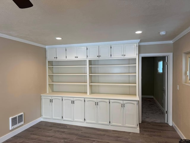 interior space featuring ornamental molding, dark hardwood / wood-style floors, and a textured ceiling