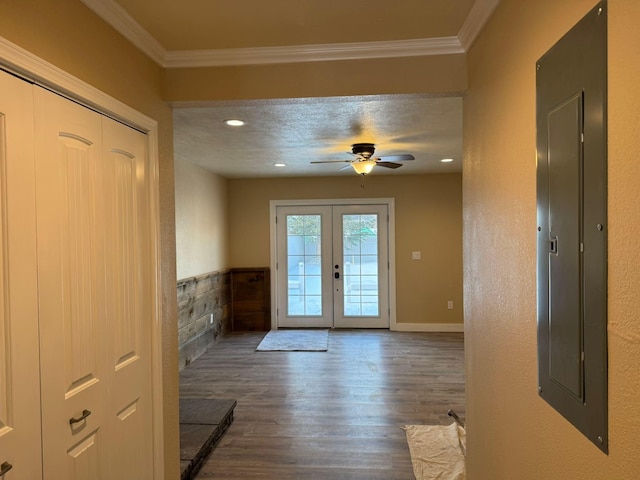 doorway with dark wood-type flooring, ceiling fan, electric panel, ornamental molding, and french doors