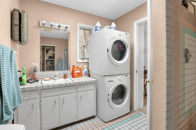 laundry room featuring sink, stacked washer and clothes dryer, and light tile patterned flooring