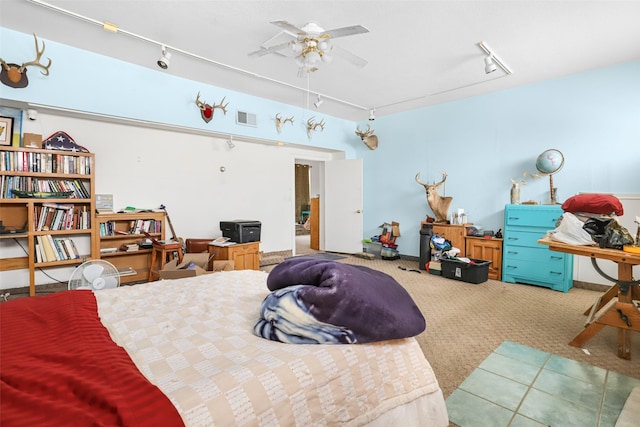 bedroom featuring rail lighting, carpet, and ceiling fan