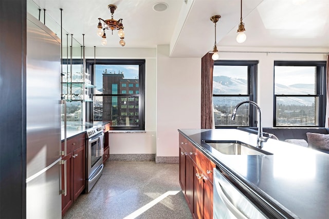 kitchen with stainless steel appliances, decorative light fixtures, and sink