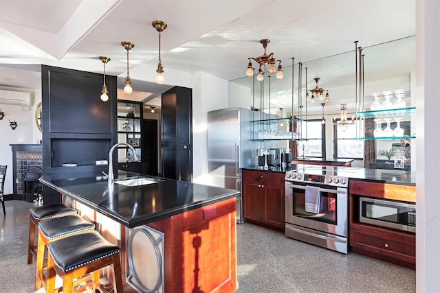 kitchen featuring pendant lighting, sink, a wall unit AC, stainless steel appliances, and a center island