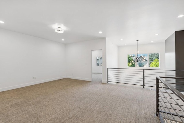 unfurnished room with a notable chandelier and carpet