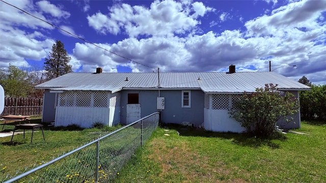 rear view of house with a chimney and metal roof