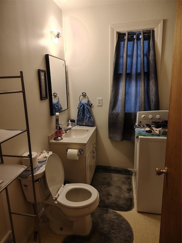 bathroom with washer / dryer, toilet, vanity, and baseboards