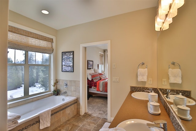 bathroom featuring vanity and tiled bath