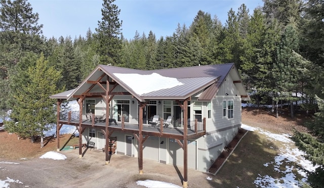 rear view of property with a garage and a deck